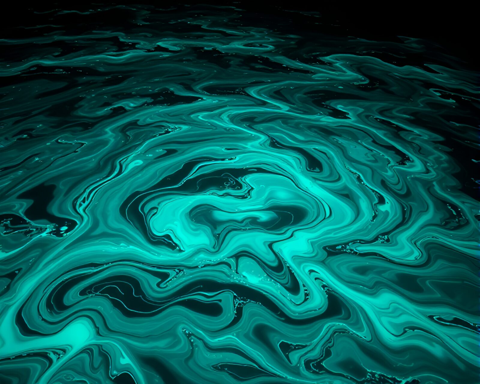 Stunning image of bioluminescent ink swirling in ocean with intricate graphic patterns