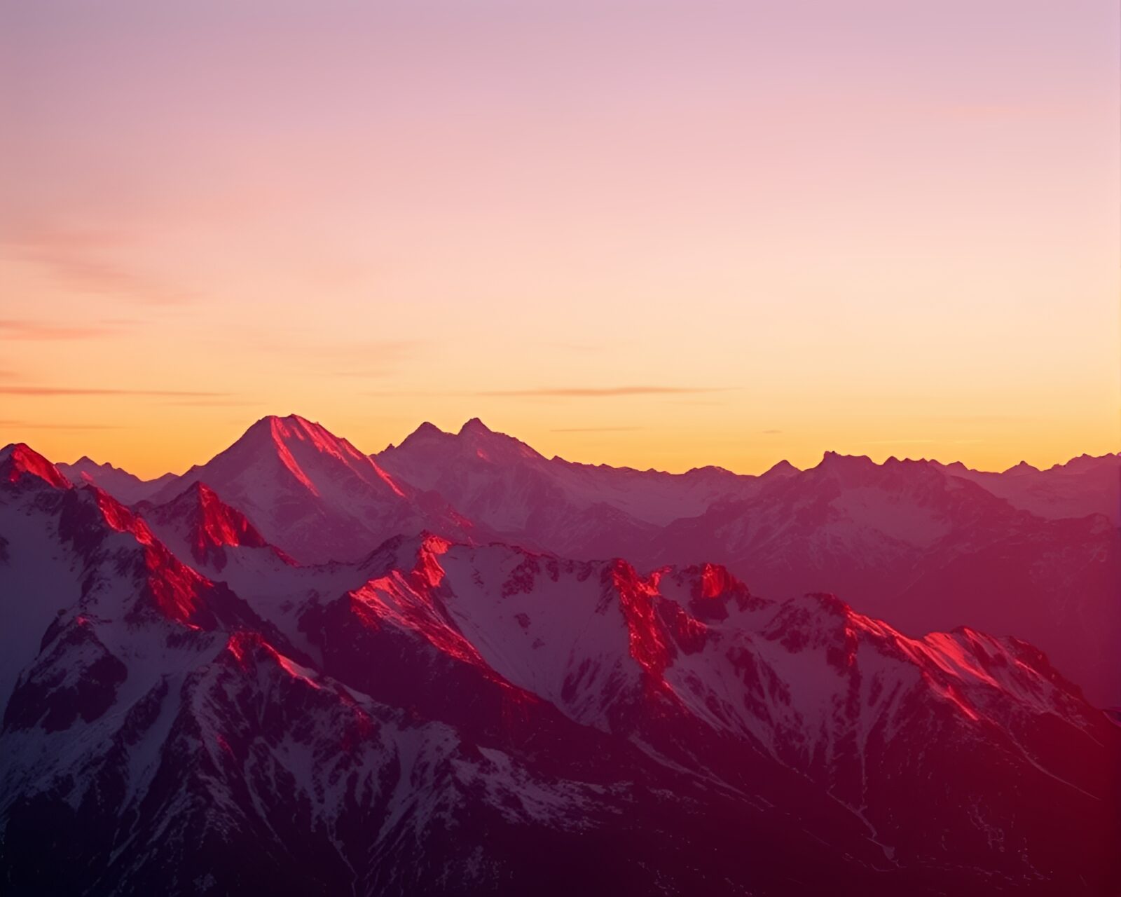 Stunning sunrise illuminating snow-capped mountains under colorful sky