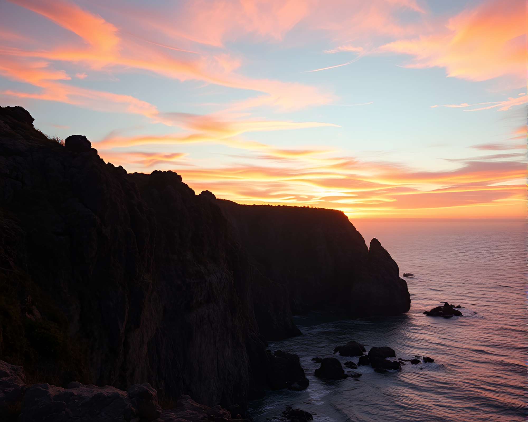 Dramatic Sunset Over Rocky Coastal Landscape – free AI stock image
