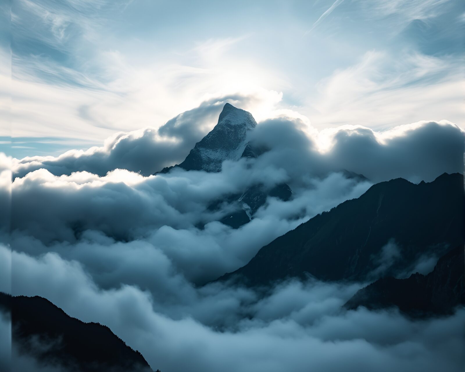 Dramatic mountain summit emerging above thick, swirling clouds