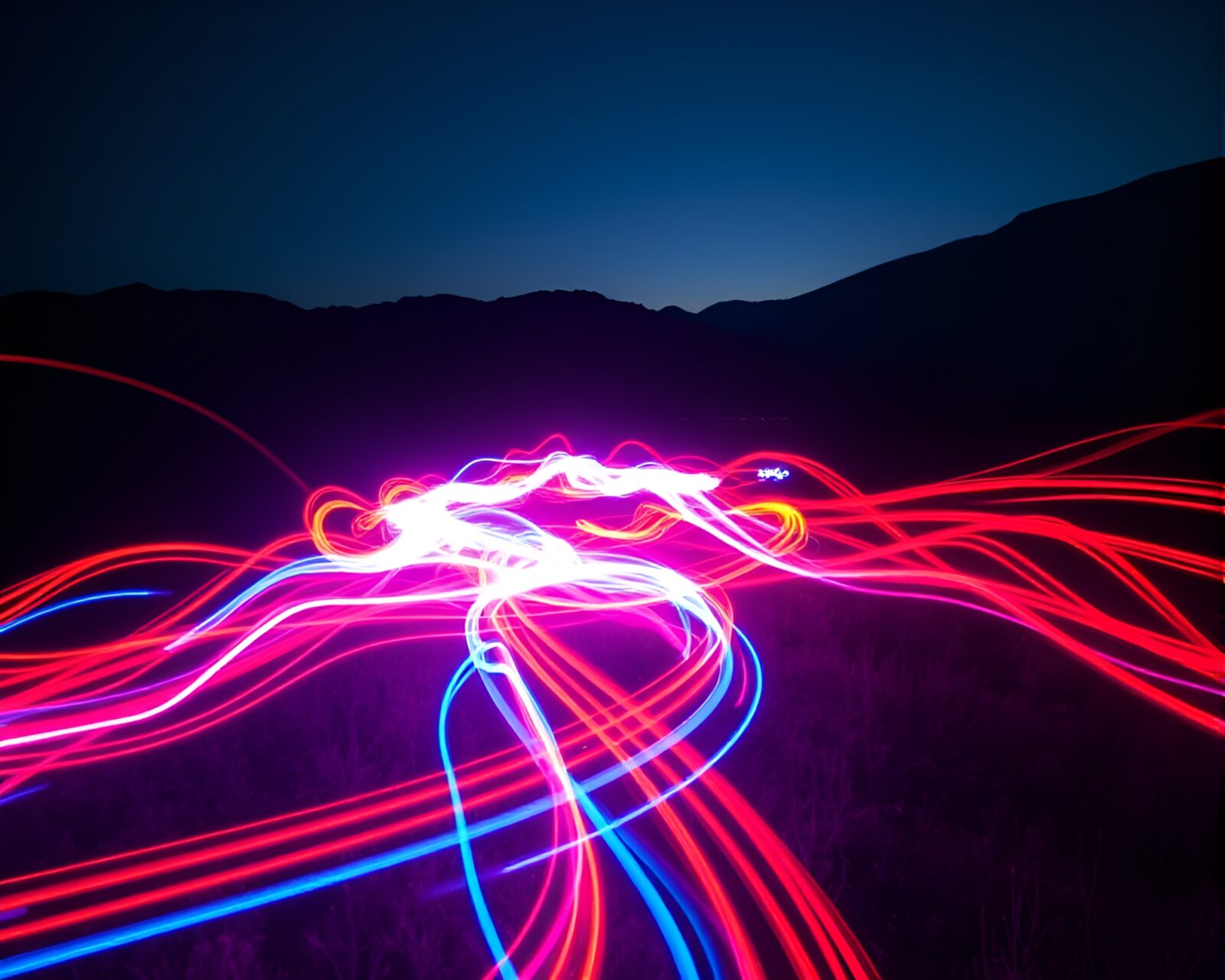 Vibrant light trails swirling on dark landscape with movement