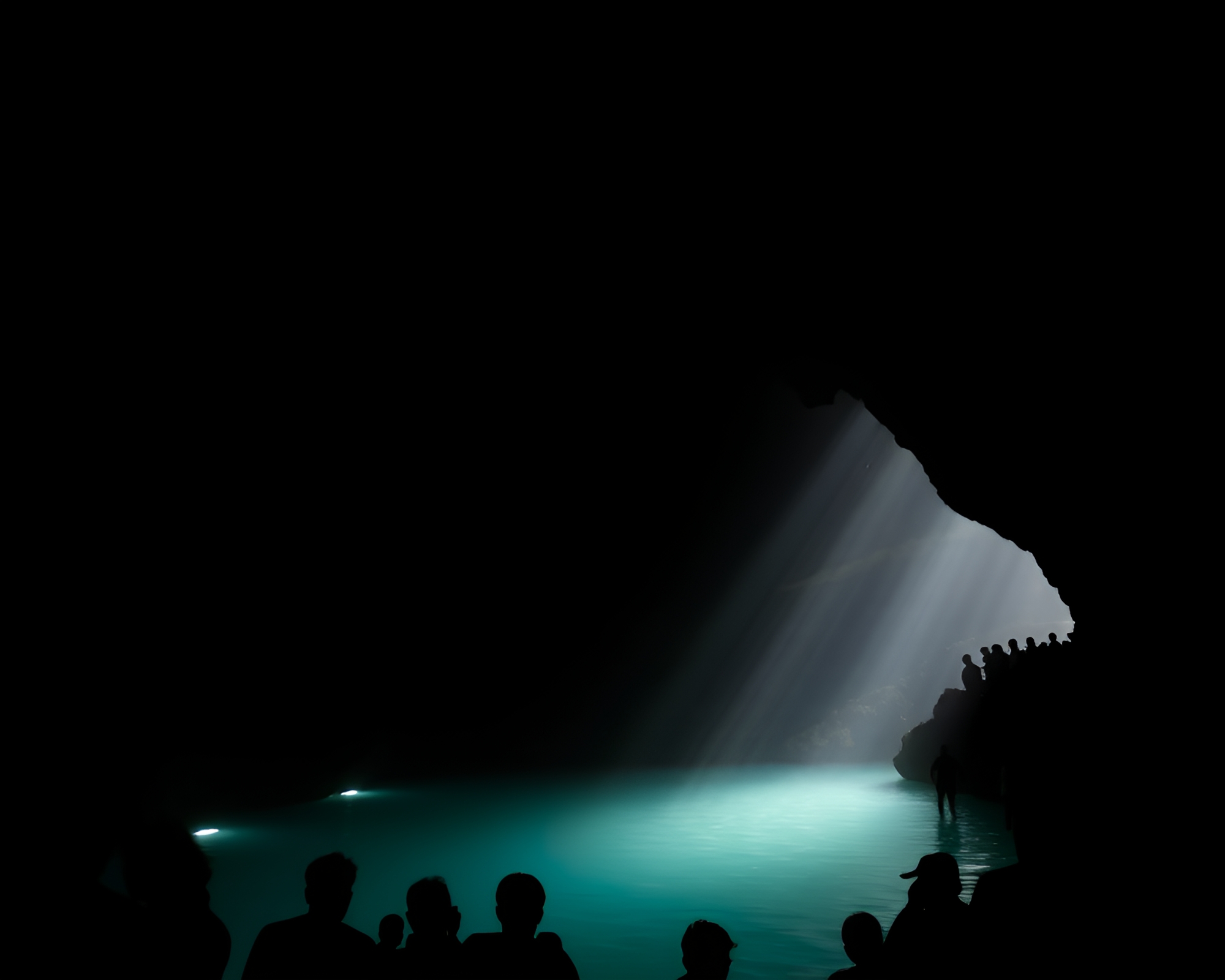 Silhouetted Crowd Approaching Dark Cave Hot Spring – free AI stock image