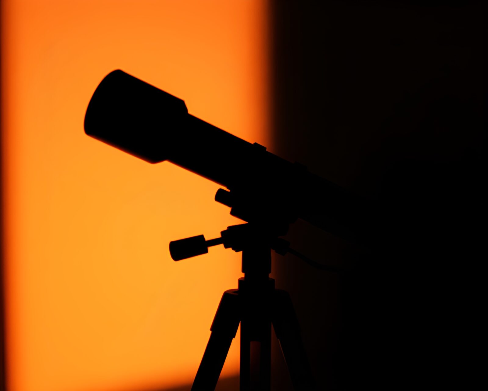 Shadowed figure peers into glowing telescope in 3D