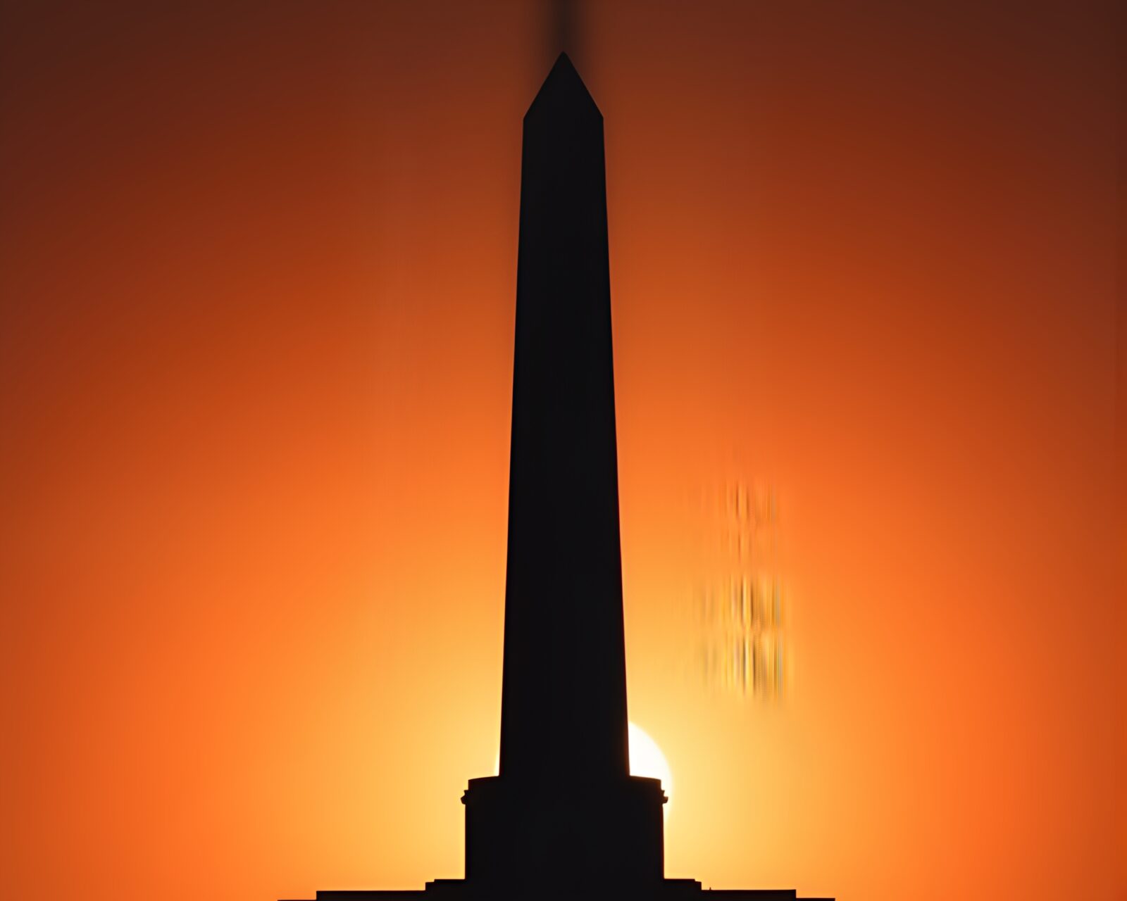 Copper-hued shadow of obelisk against dynamic sky