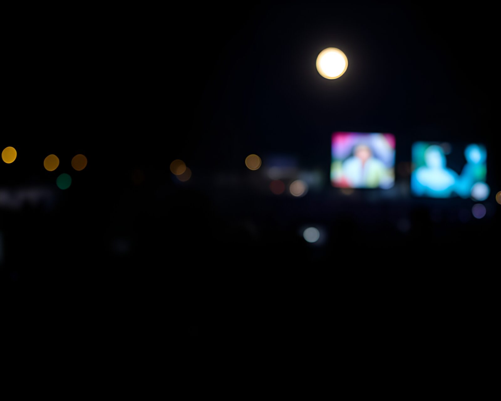 Crowd silhouettes swirling in moonlit time vortex bokeh