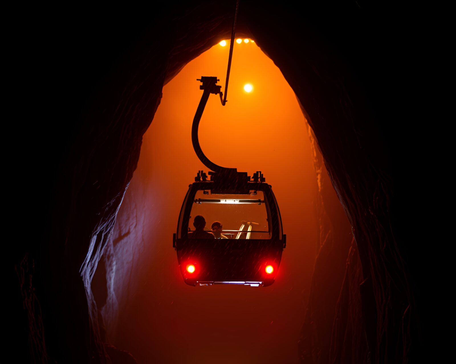 Colorful car light trails in dark cave with Gondola lift