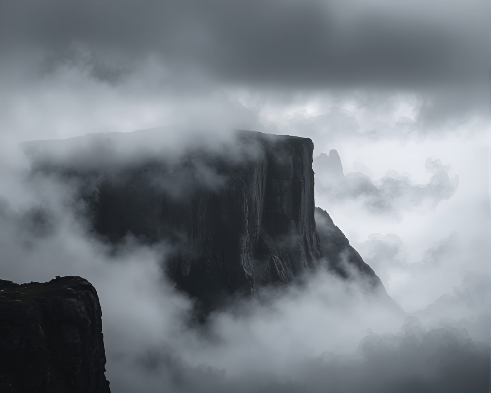 A grayscale artwork of a mist-covered cliff created with charcoal strokes