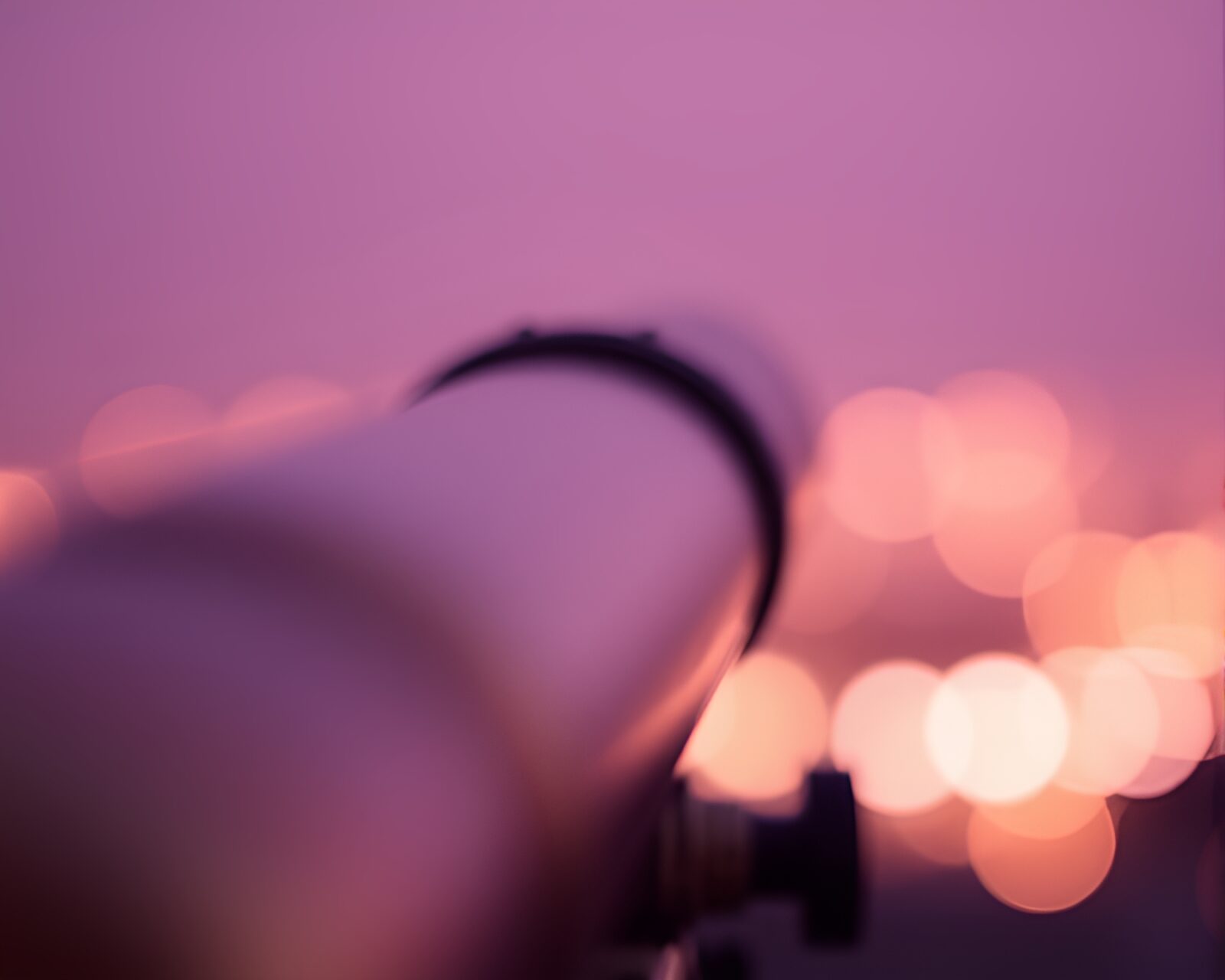 Brass telescope surrounded by dreamy bokeh in blush tones