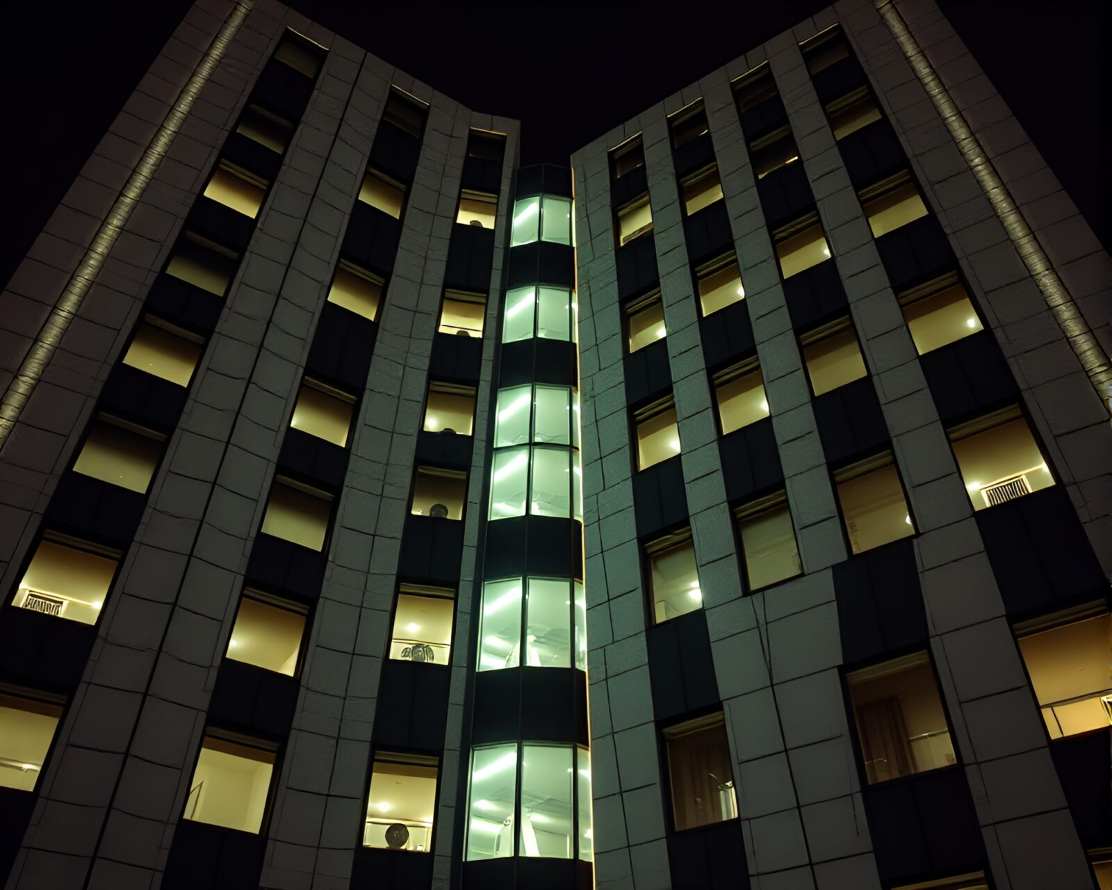 Abstract view of a crosshatched Brutalist building under fluorescent lighting.