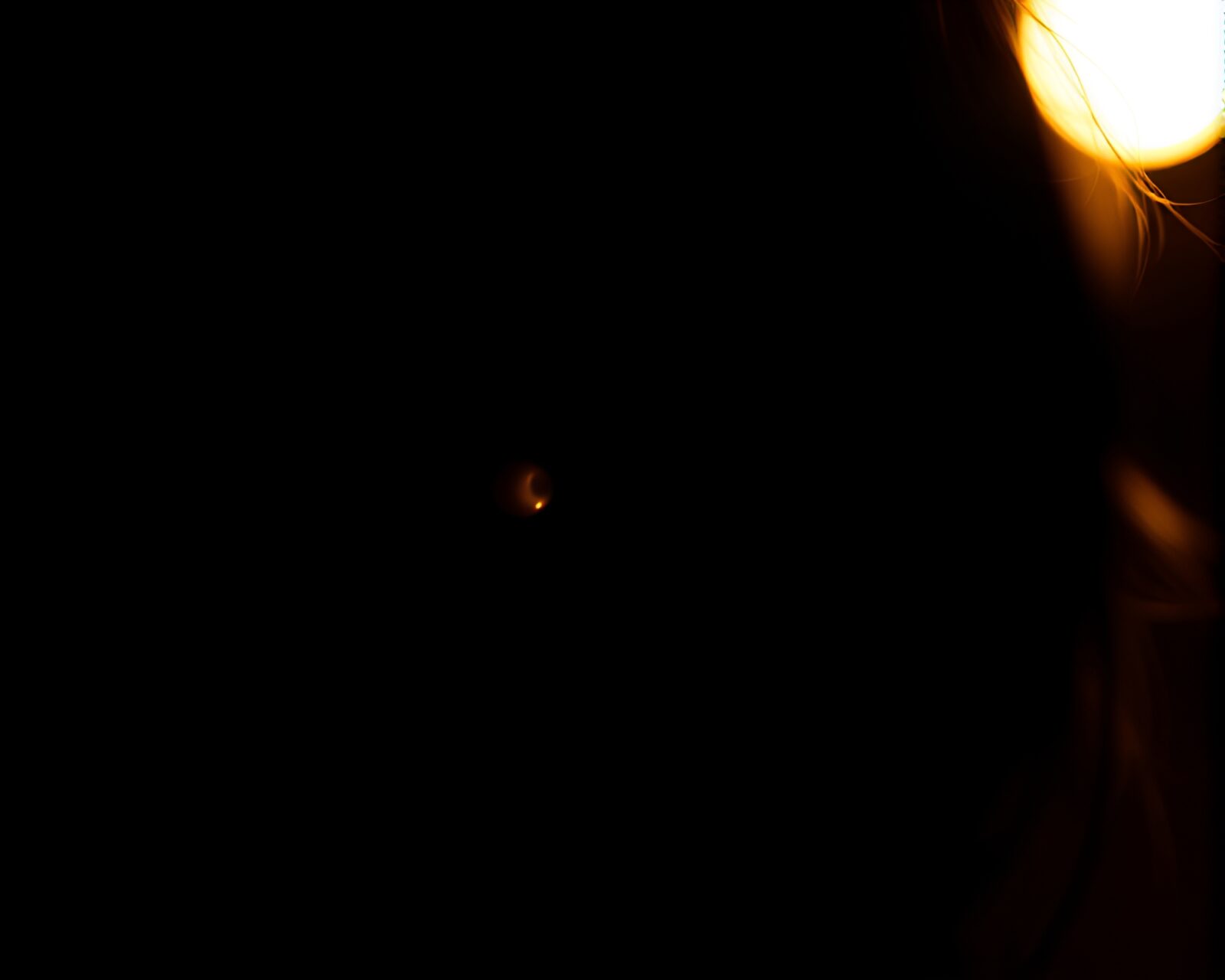 A glowing contact lens reflecting a silhouette against softbox lighting