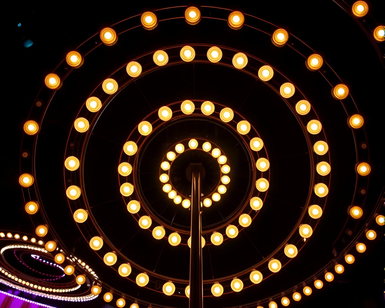 Vibrant carnival lights illuminate a cello in fluorescent circles