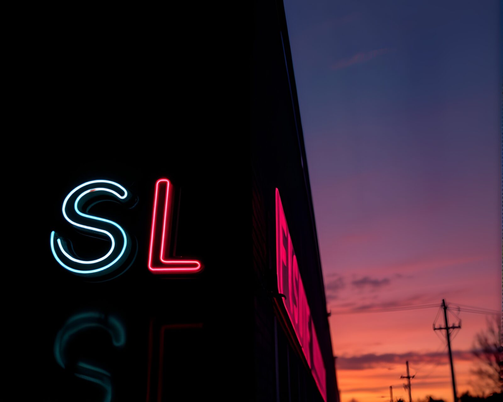 Neon sign reflected in water at warm sunset with chalk drawing art style