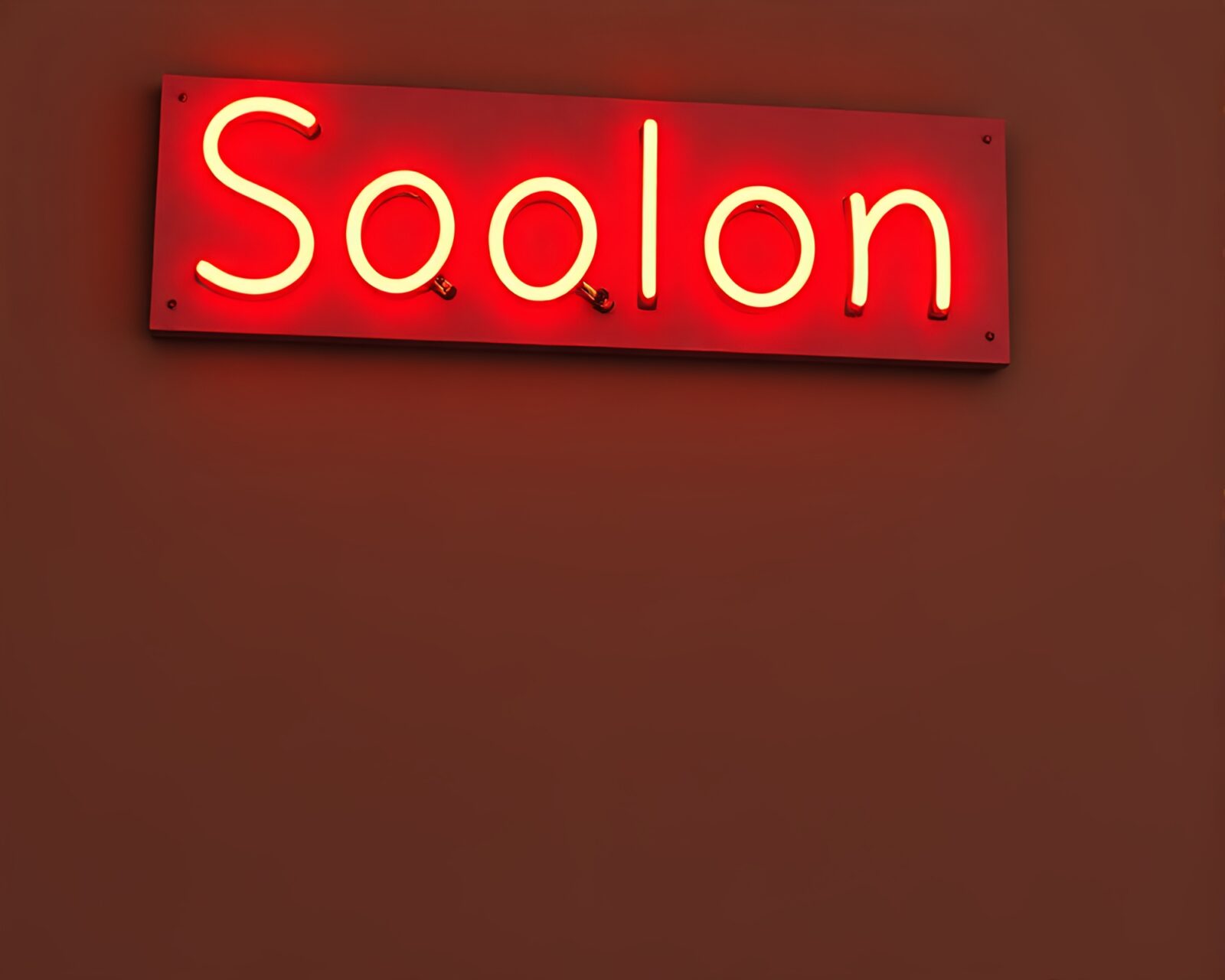 Muted earth tones illuminate neon sign on paper texture