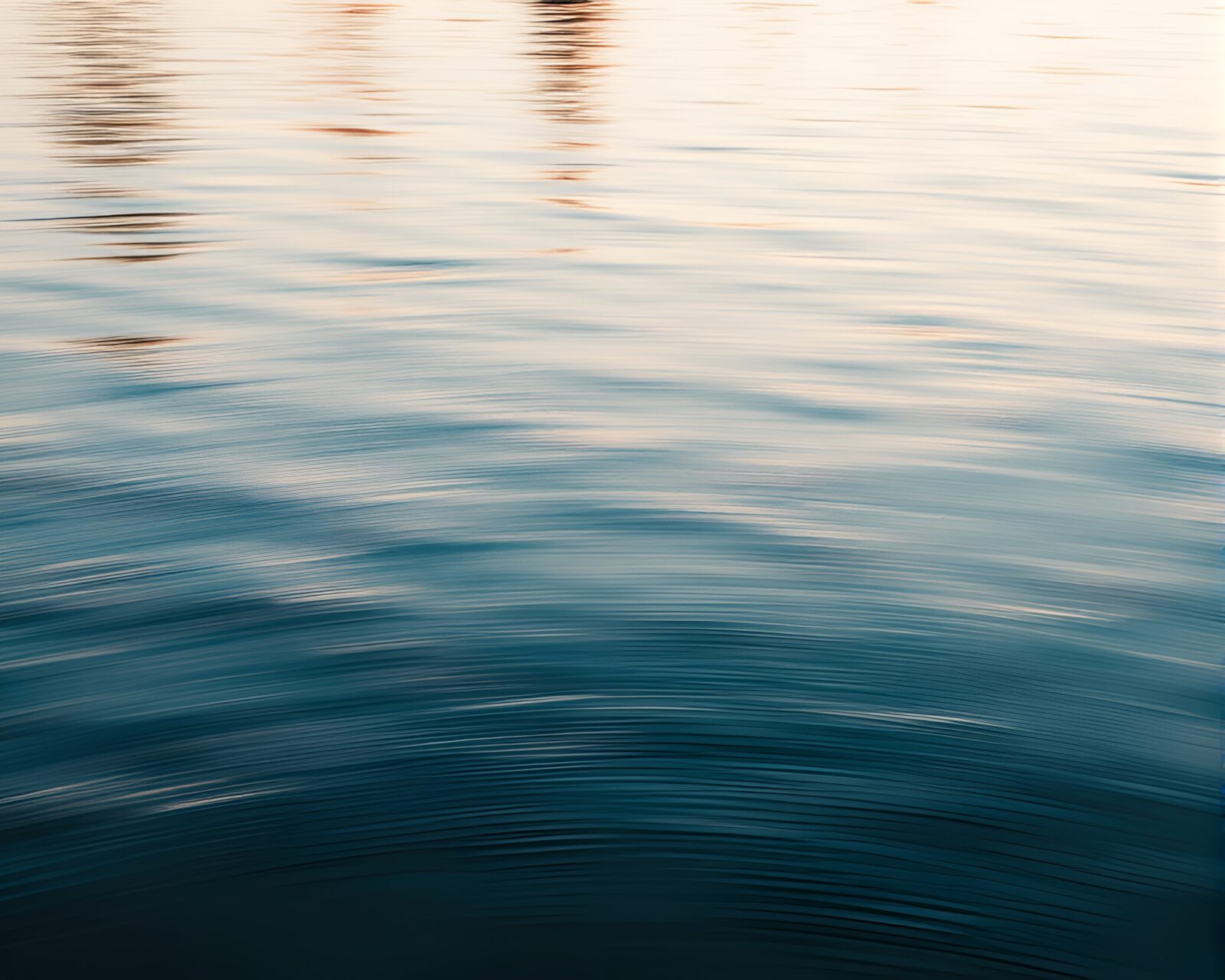 Elegant sailing vessel with motion-blurred water reflections at sunset