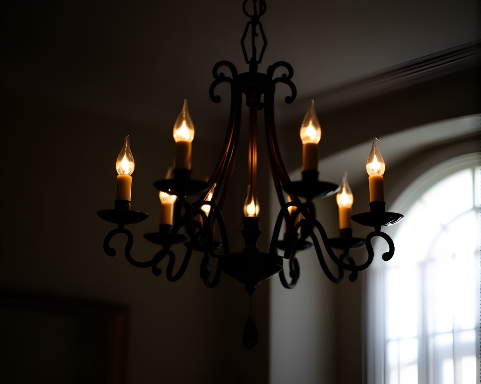 Chandelier casting shadow silhouettes in atmospheric candlelight