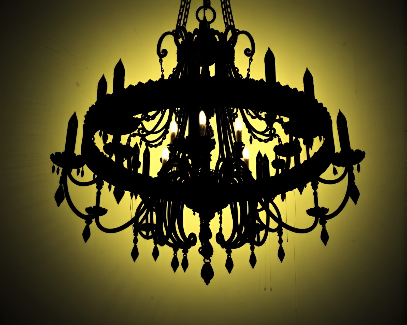 Dark chandelier in unique spatter painting, silhouetted against a gloomy backdrop