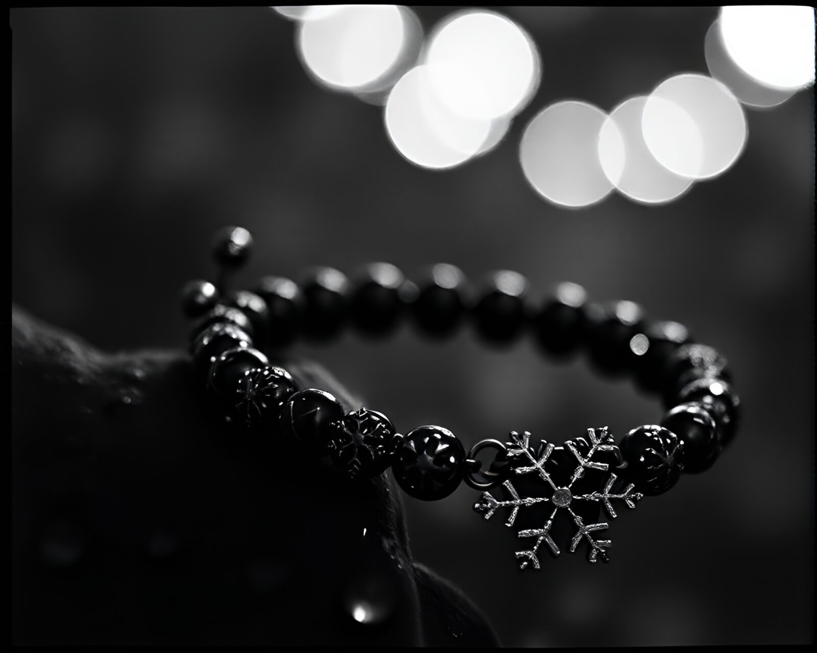 High-contrast image with snowflake bracelet in film grain mood