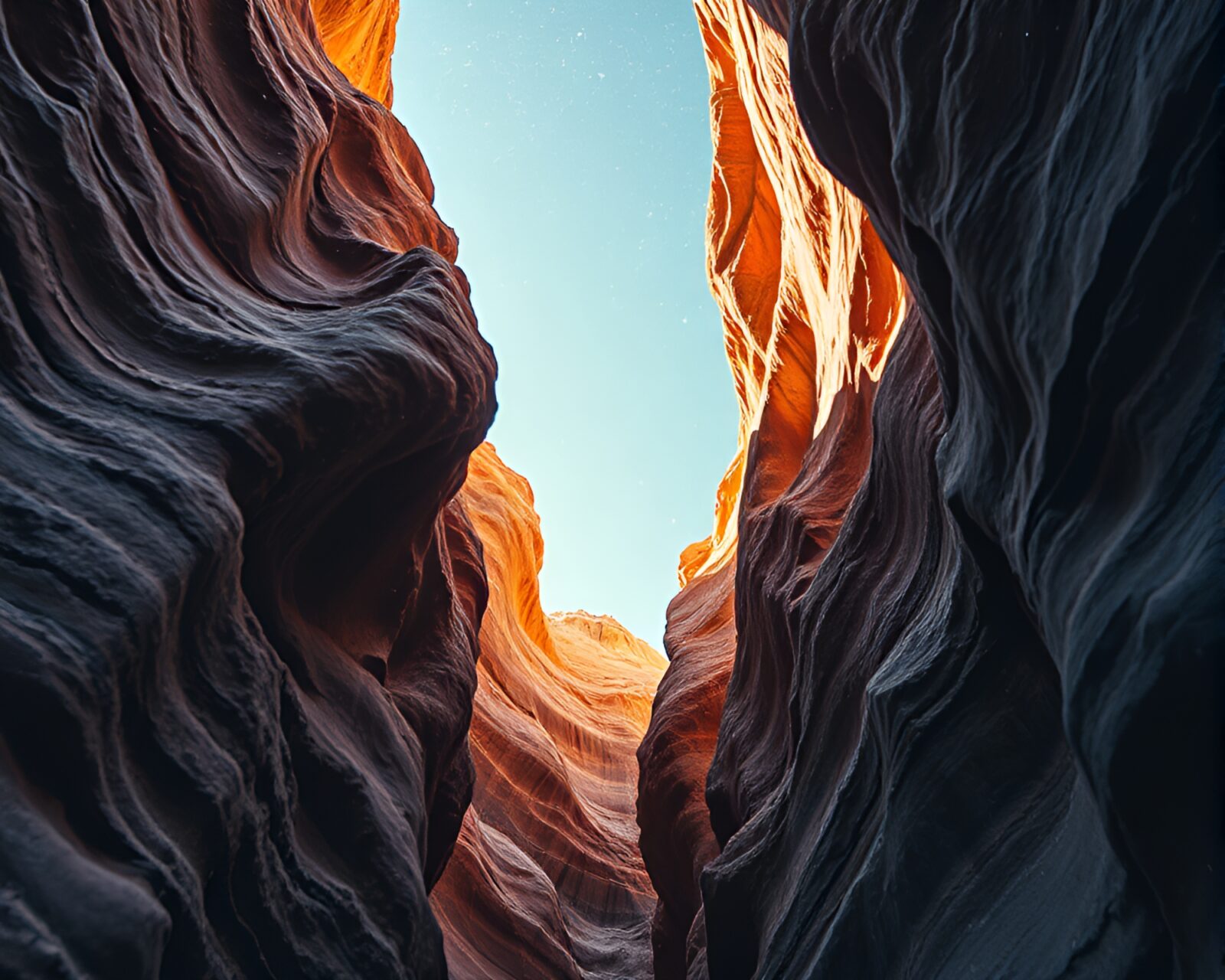 Low-angle view of an eroded canyon under stardust sky.