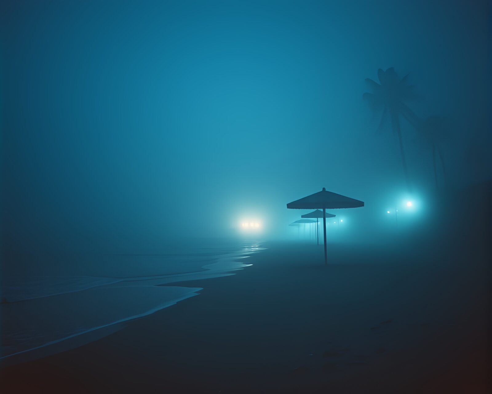 Steely-blue mist envelops beach under noir lighting.