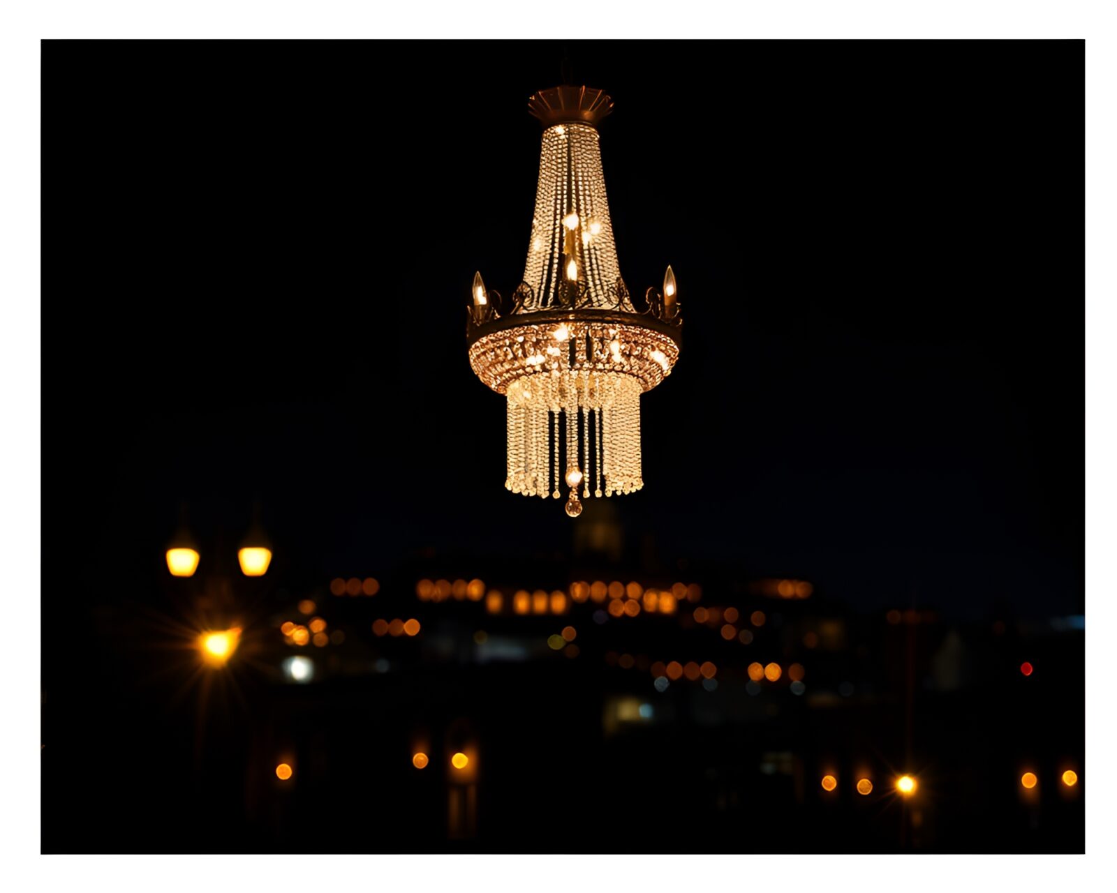 Glamorous crystal chandelier under sparkling city lights at night