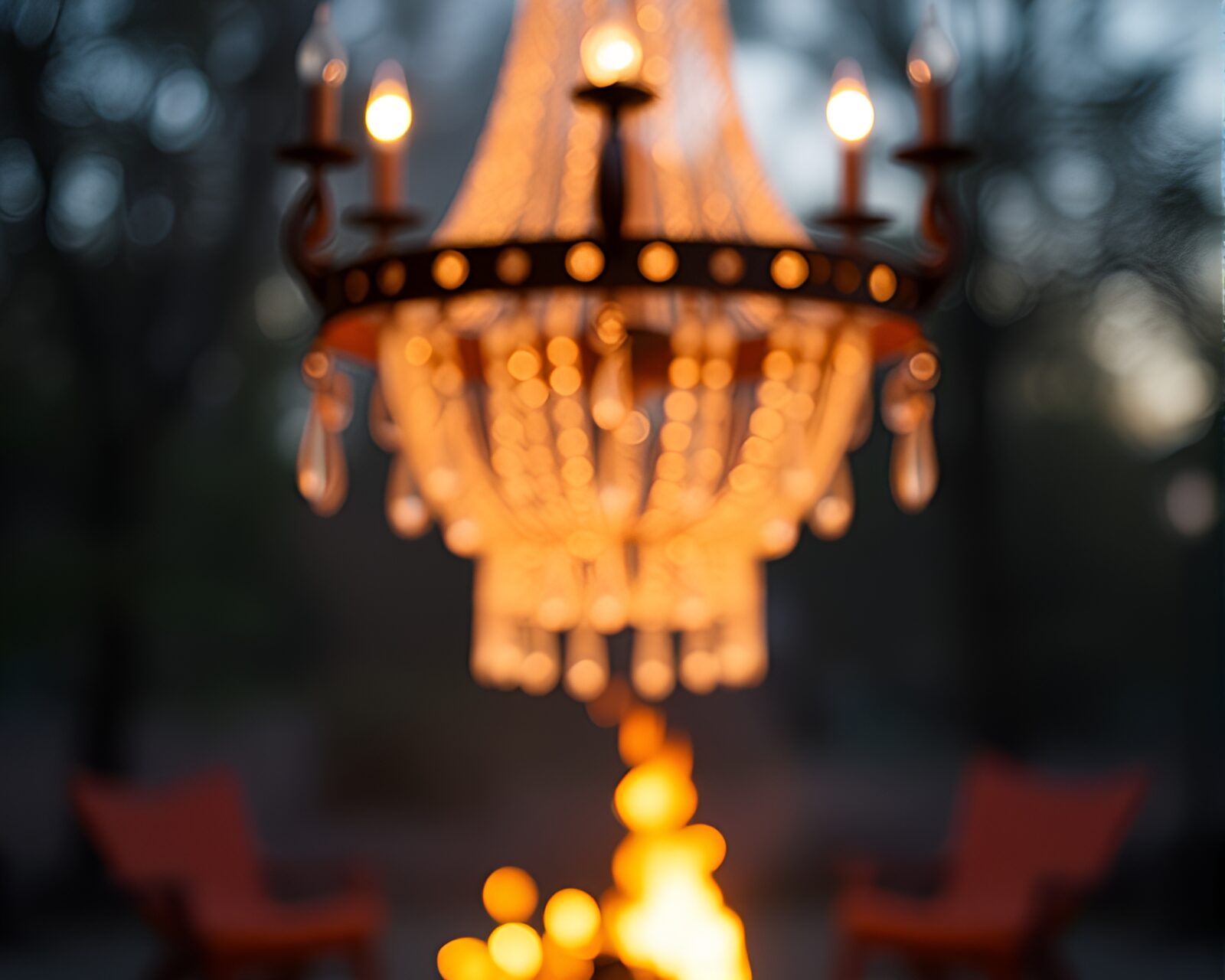 A luxurious chandelier shining in a warm bonfire-lit room
