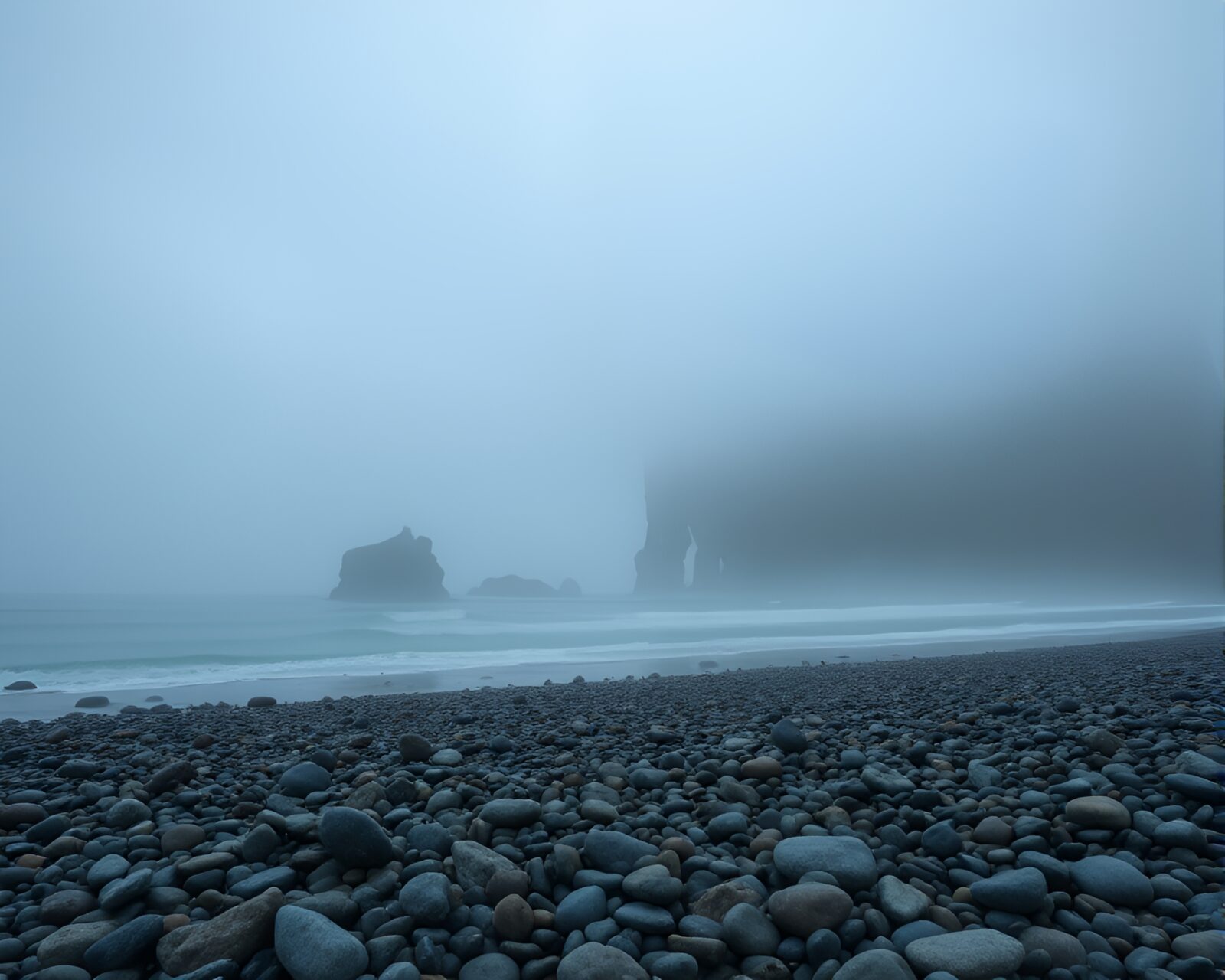 Centered pebble beach scene with foggy tattoo art style