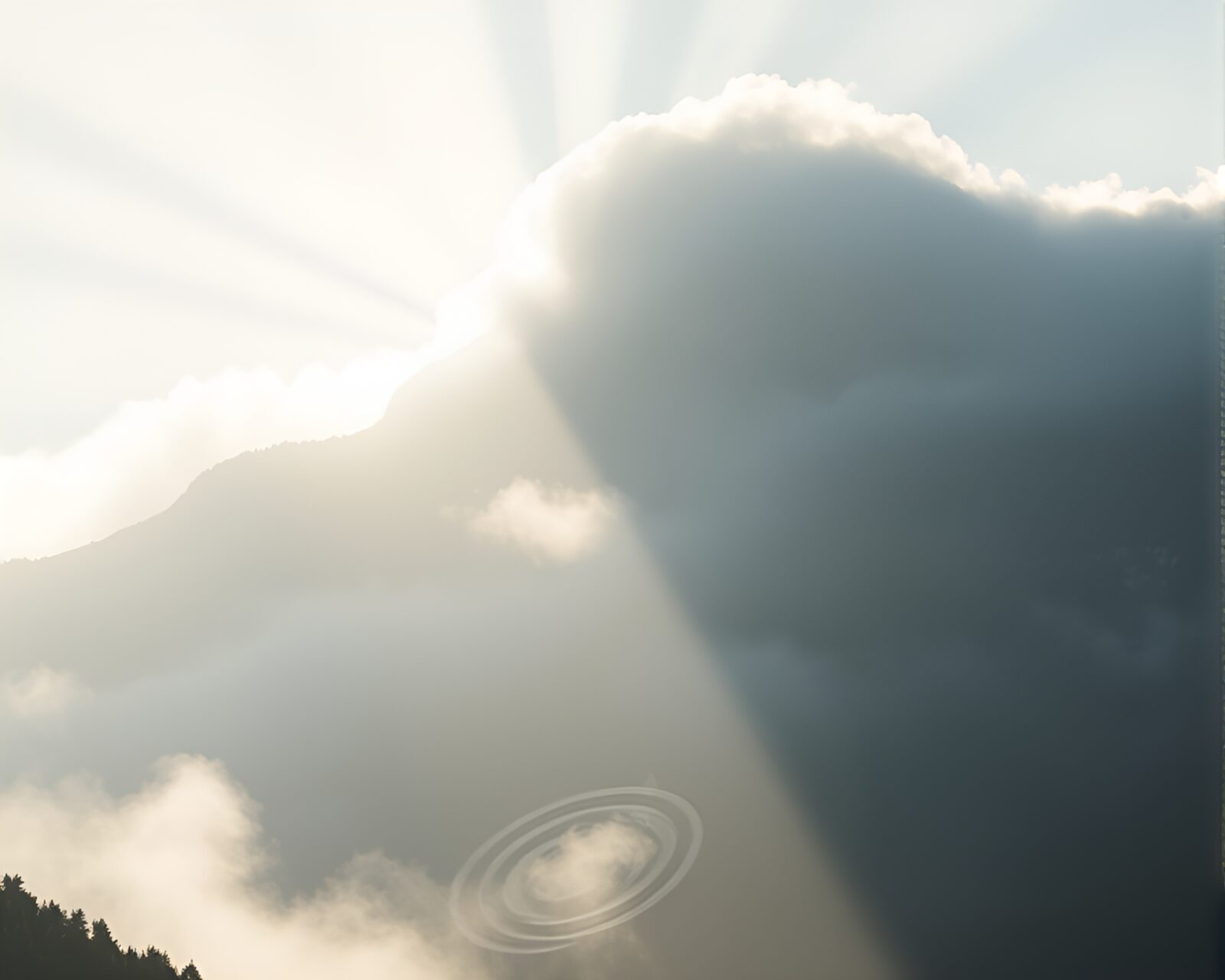 Off-center mountain in mist with ethereal light beams