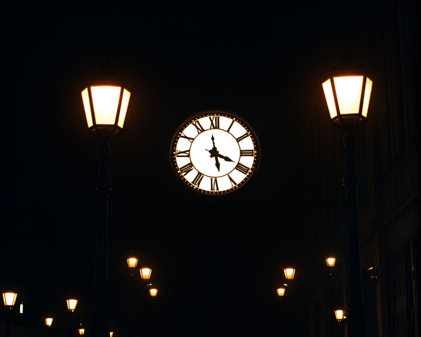 Glowing streetlamp illuminating a futuristic clock tower silhouette