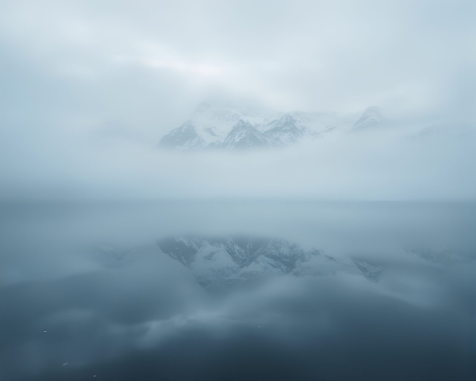 Manga-style illustration of misty, double-reflected mountain peak.