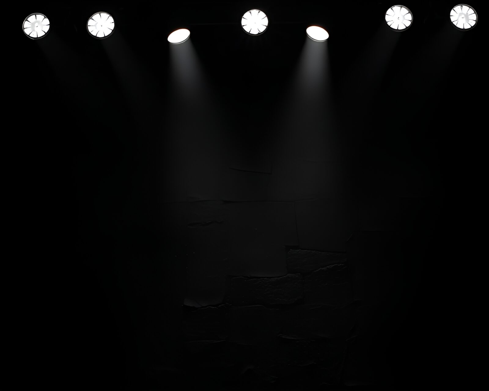 Black and white image of concert stage lights illuminating rustic pottery
