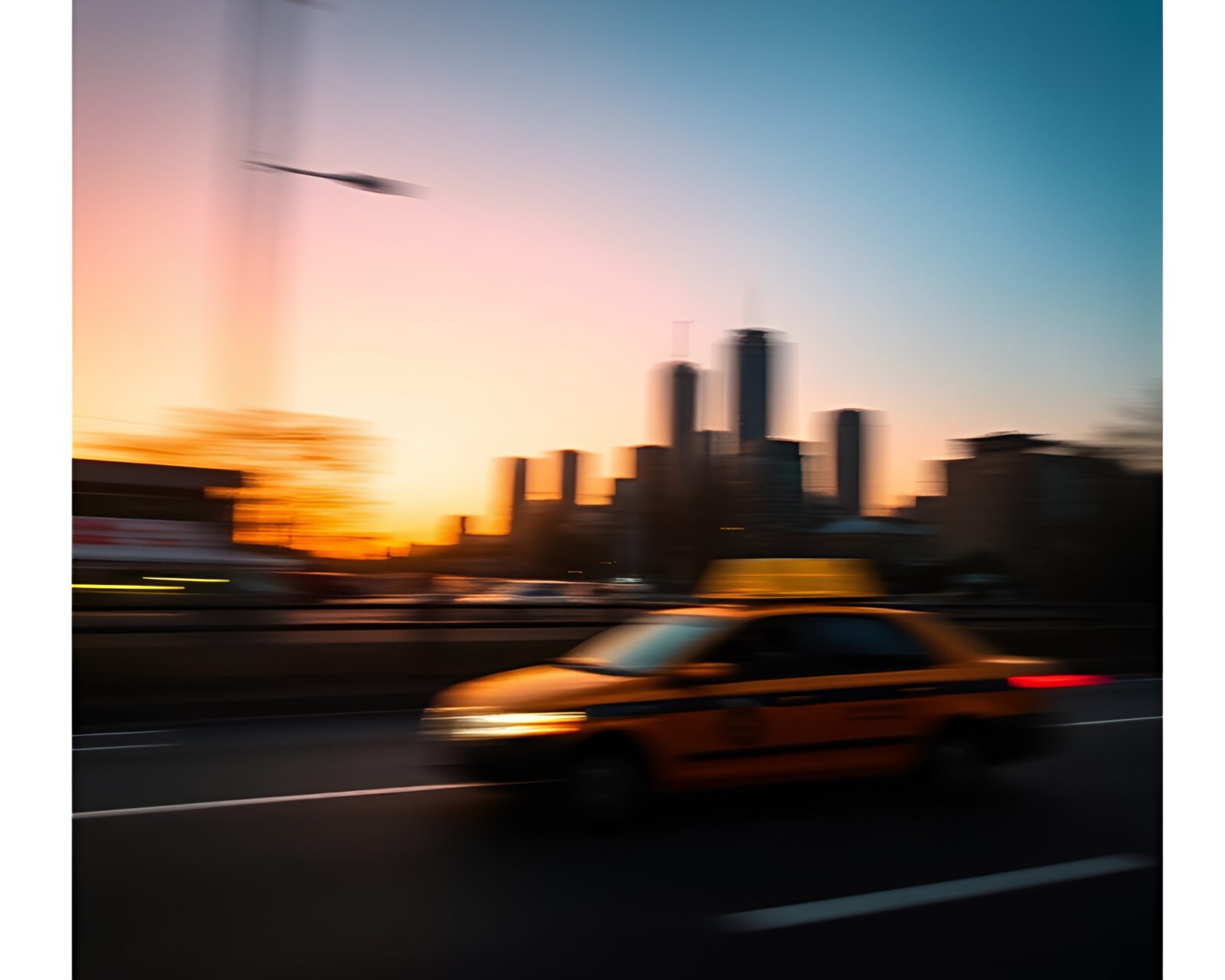 A taxi streaking through a sunset-lit city skyline