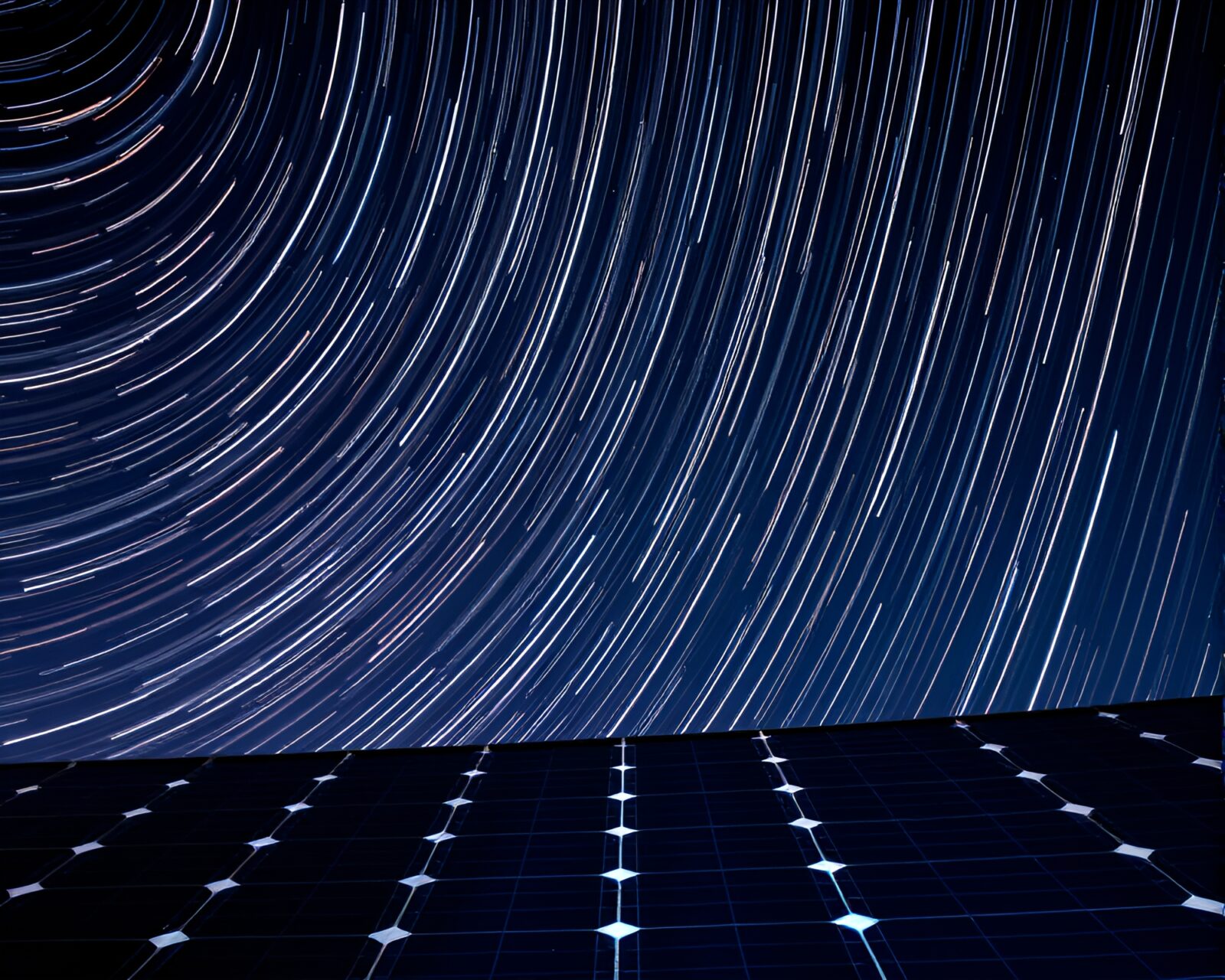 Long exposure night sky with star trails above solar panels