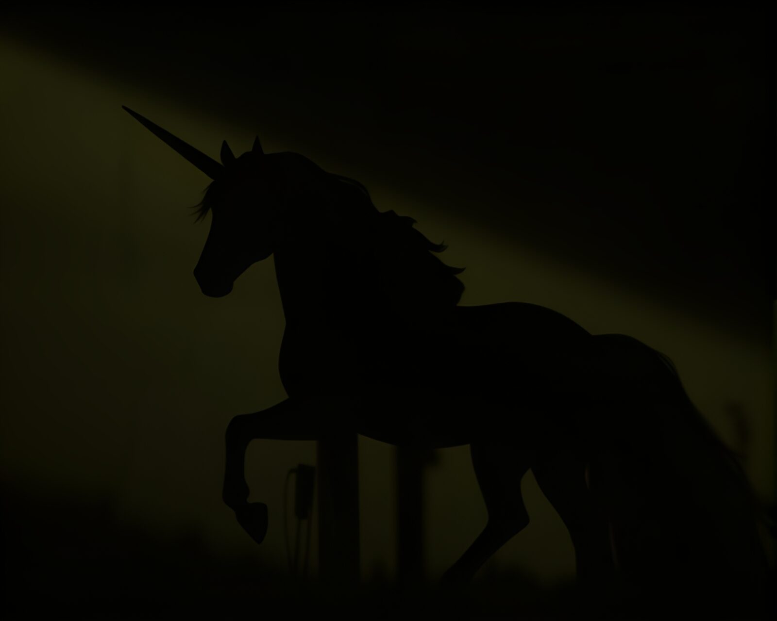 Elegant unicorn standing in dramatic shadow silhouette