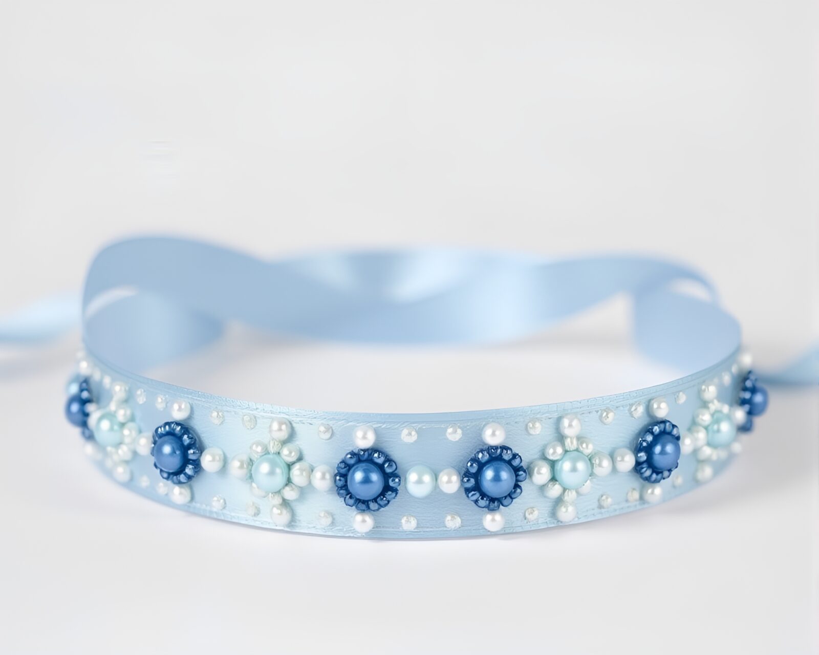 Elegant beadwork and satin ribbon with steel-blue thermal effects.