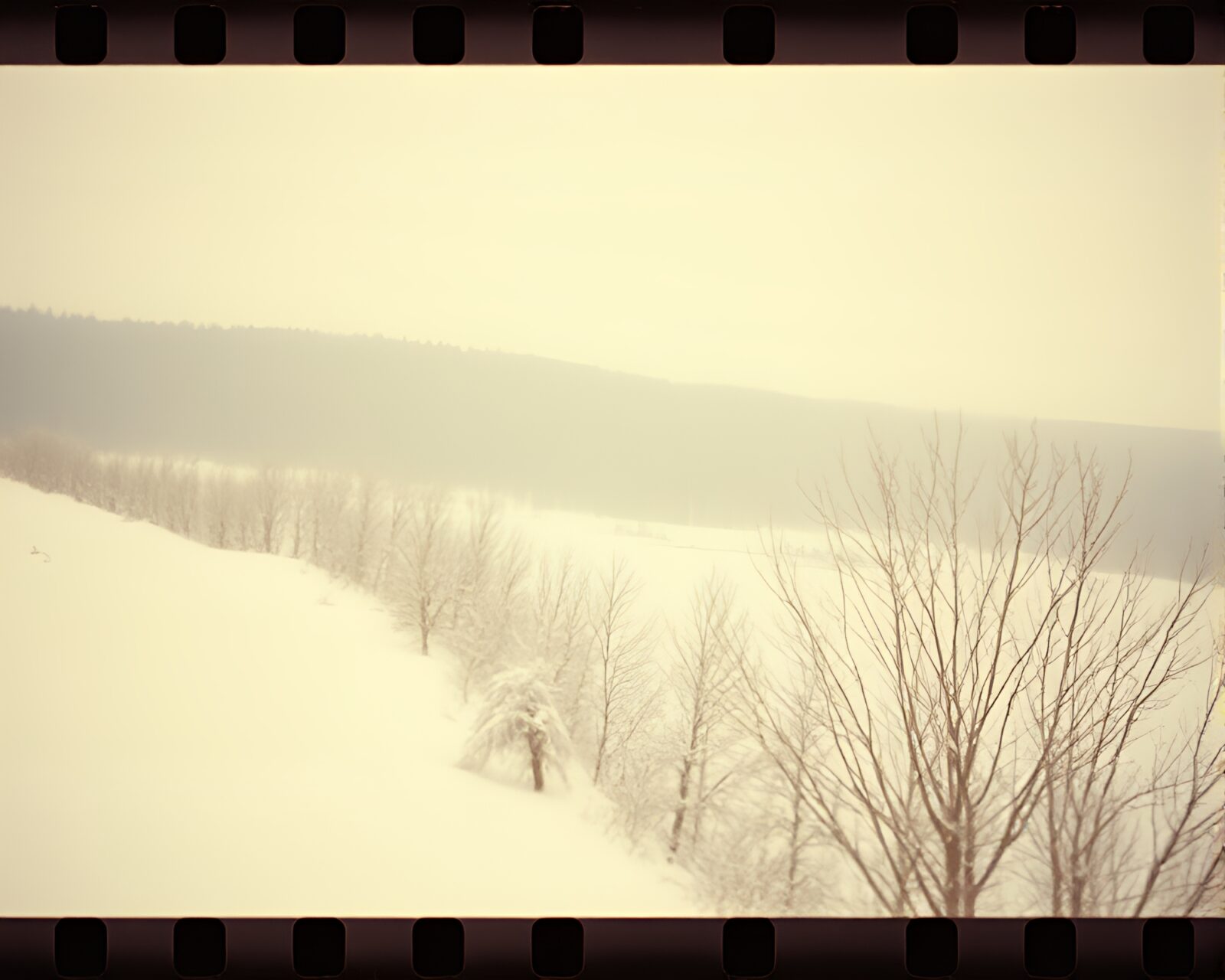 Vintage film sprocket holes with figure in snow and sepia tones