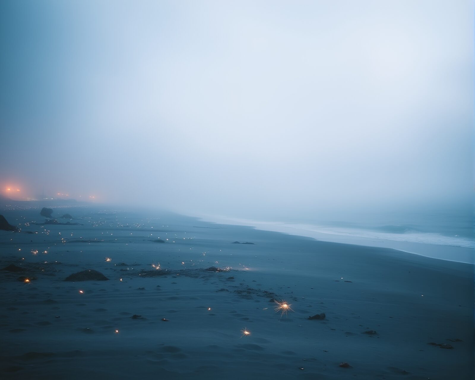 Ink wash art of sparklers creating trails on foggy beach