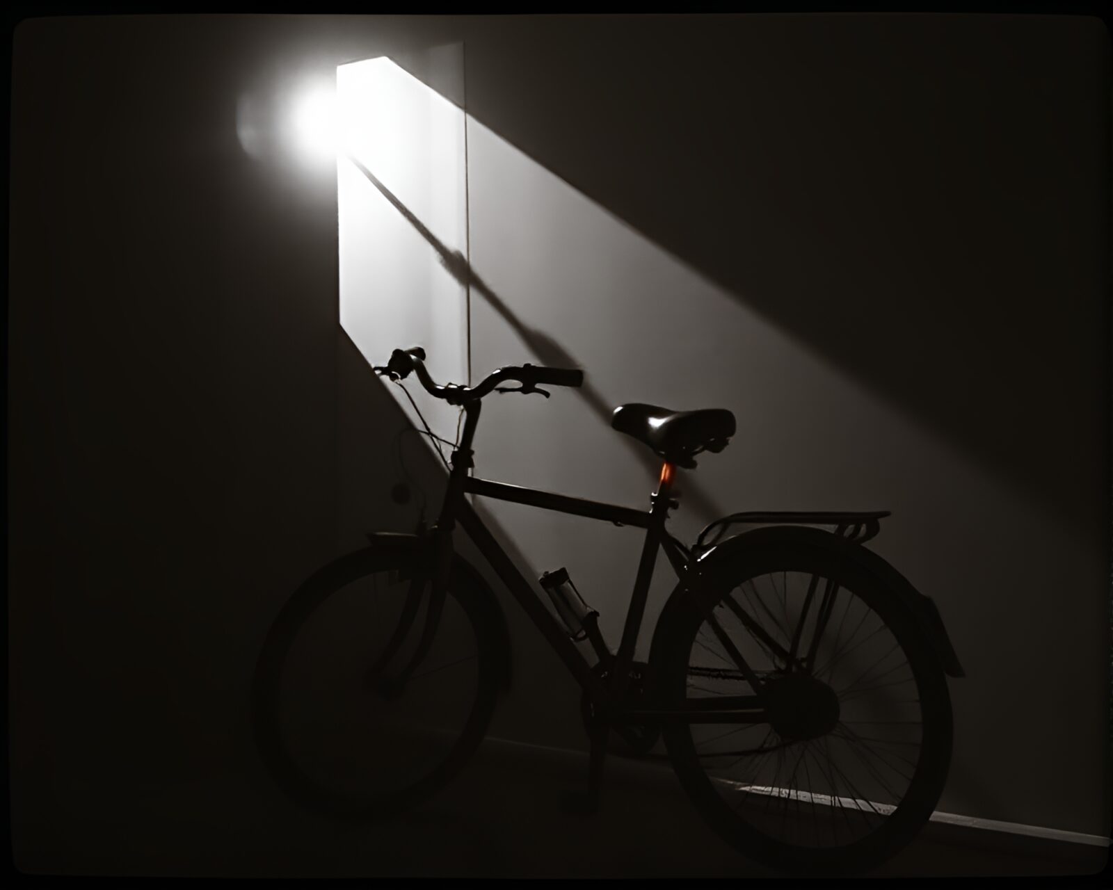 Shadowy attic scene with bike and film sprockets in duotone