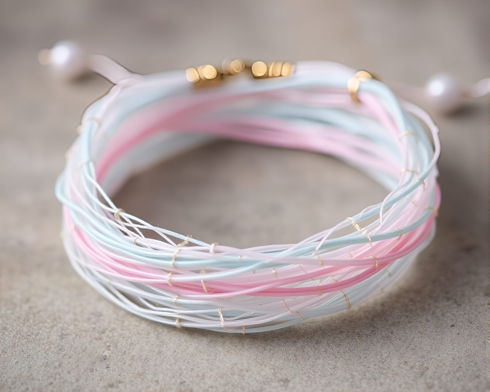 Soft pastel cobweb strands woven into delicate bracelet design.