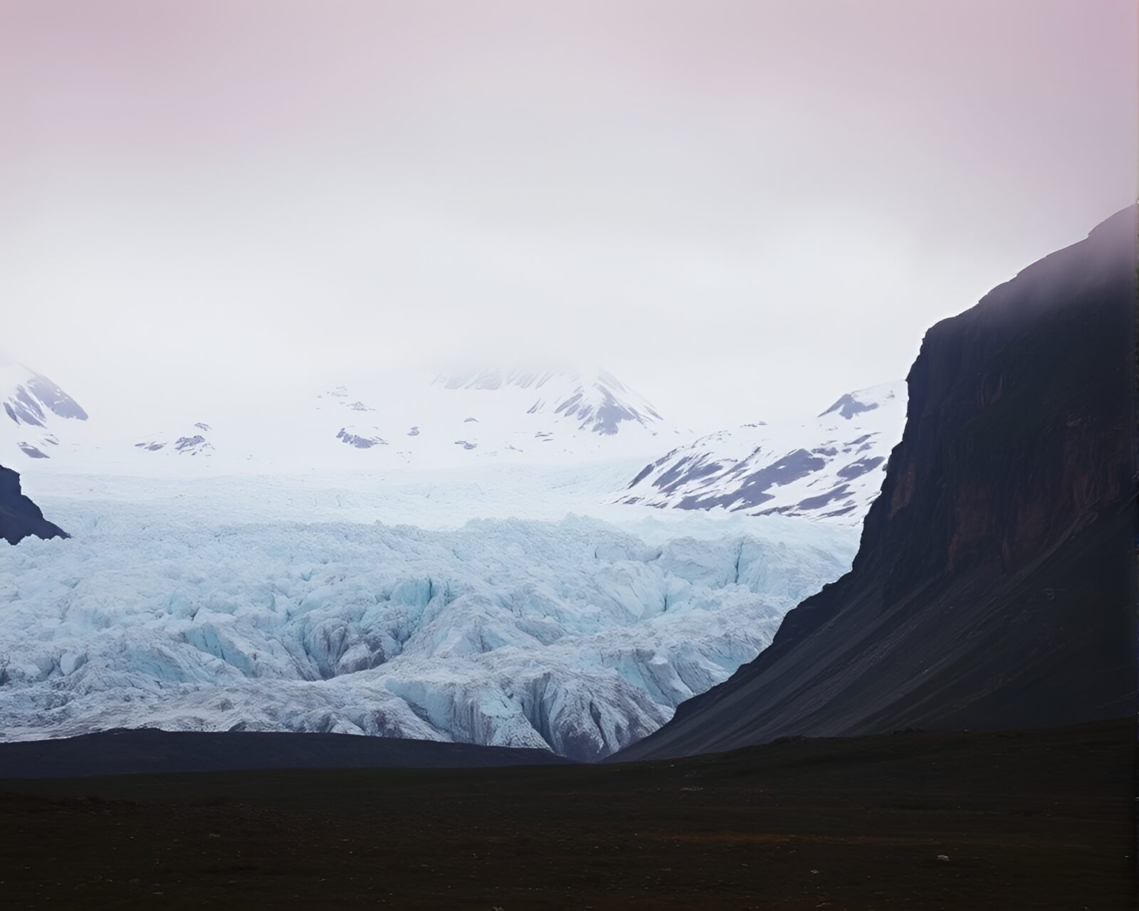 An environmental portrait of a figure lost in a glacier's deep red hues