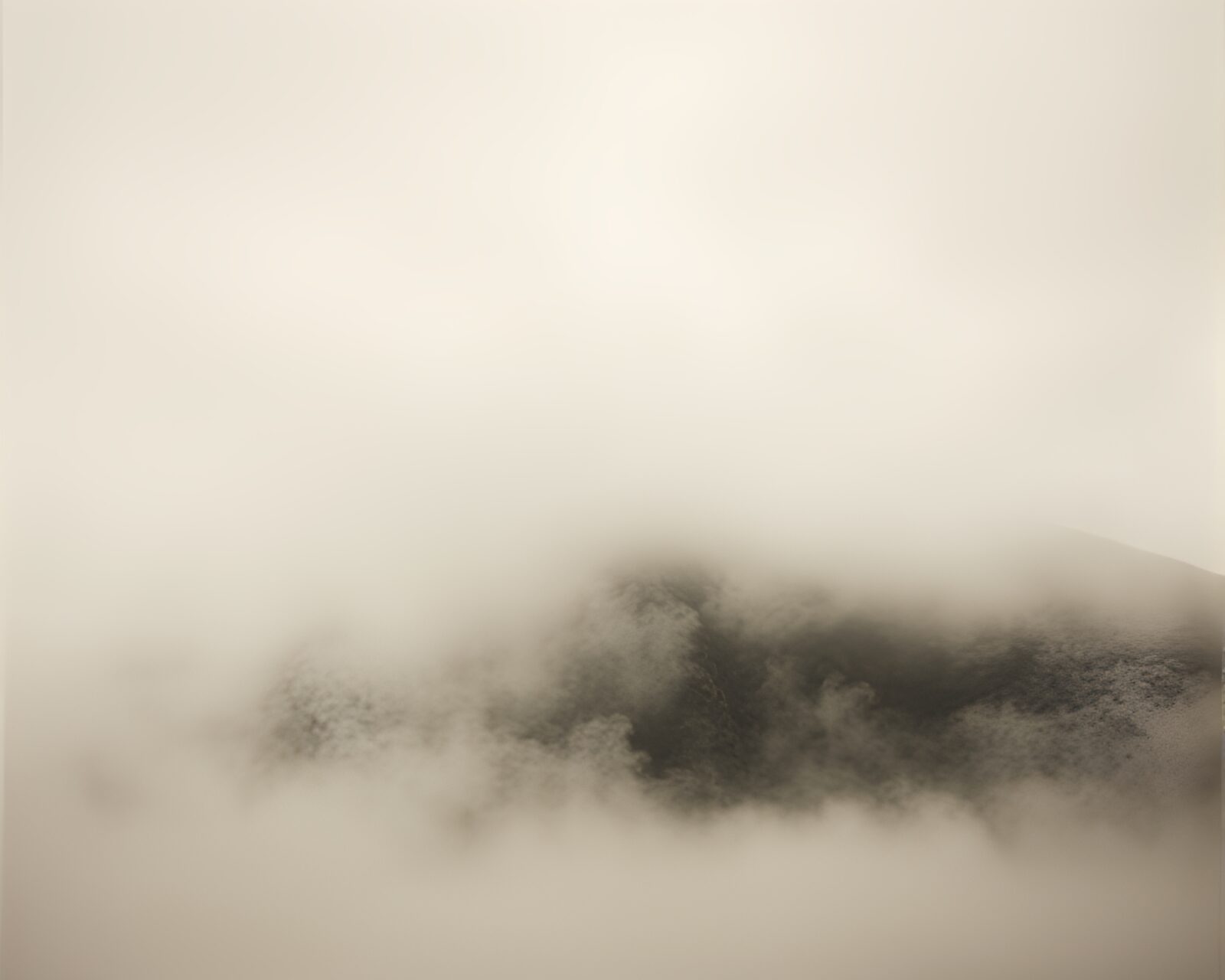 Sepia-toned mountain enveloped in cinematic mist