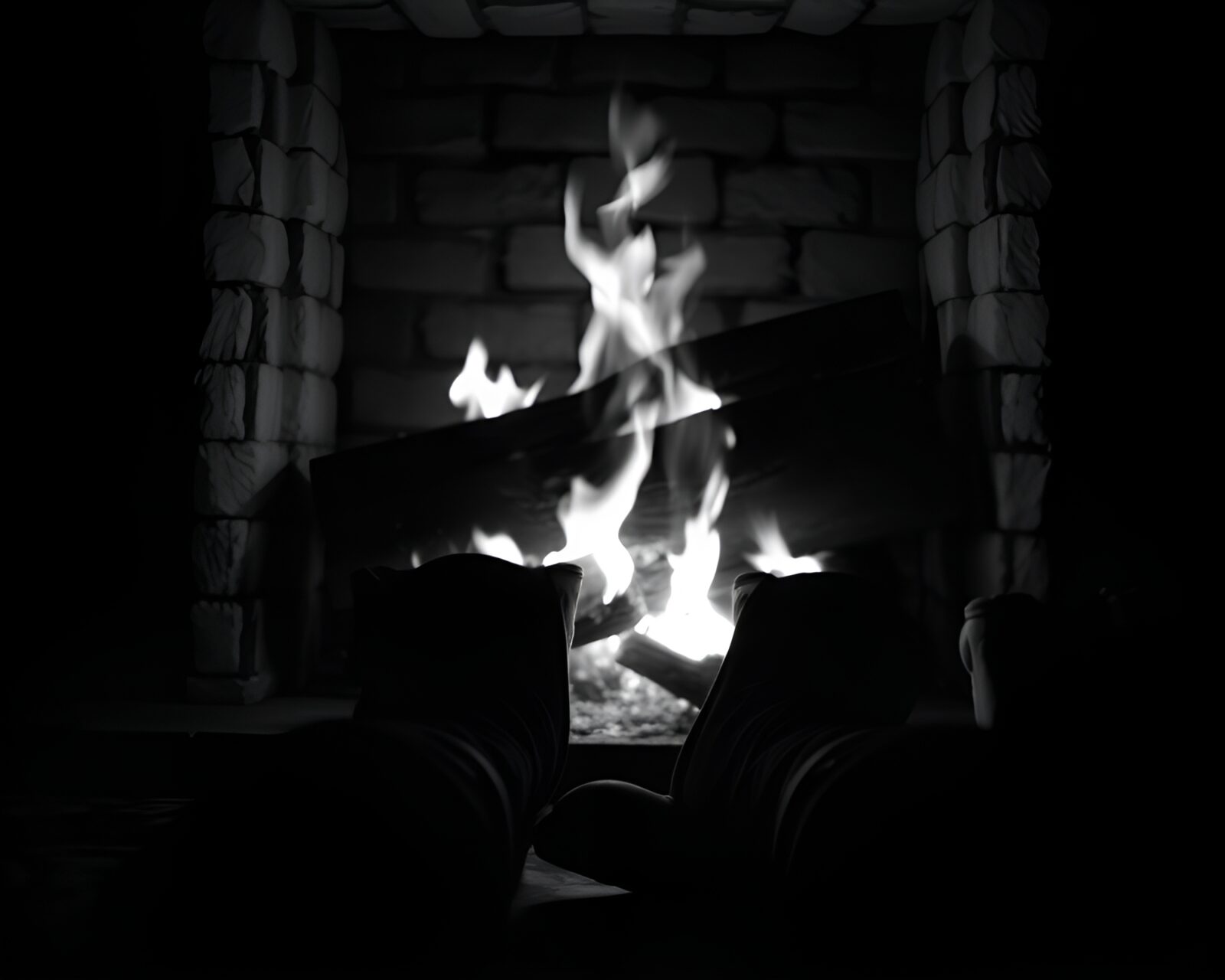 Black and white image showing gravity boots near a fireplace
