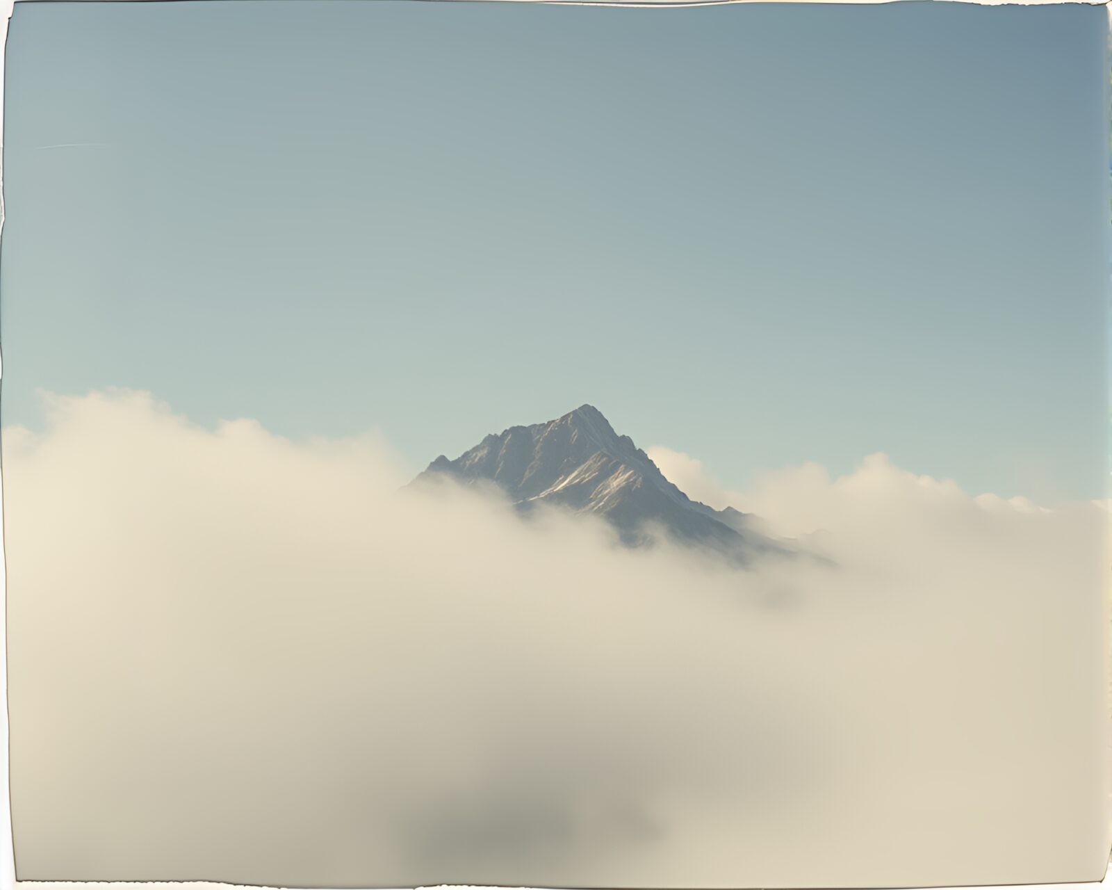 Misty mountain peak through torn vintage polaroid edges