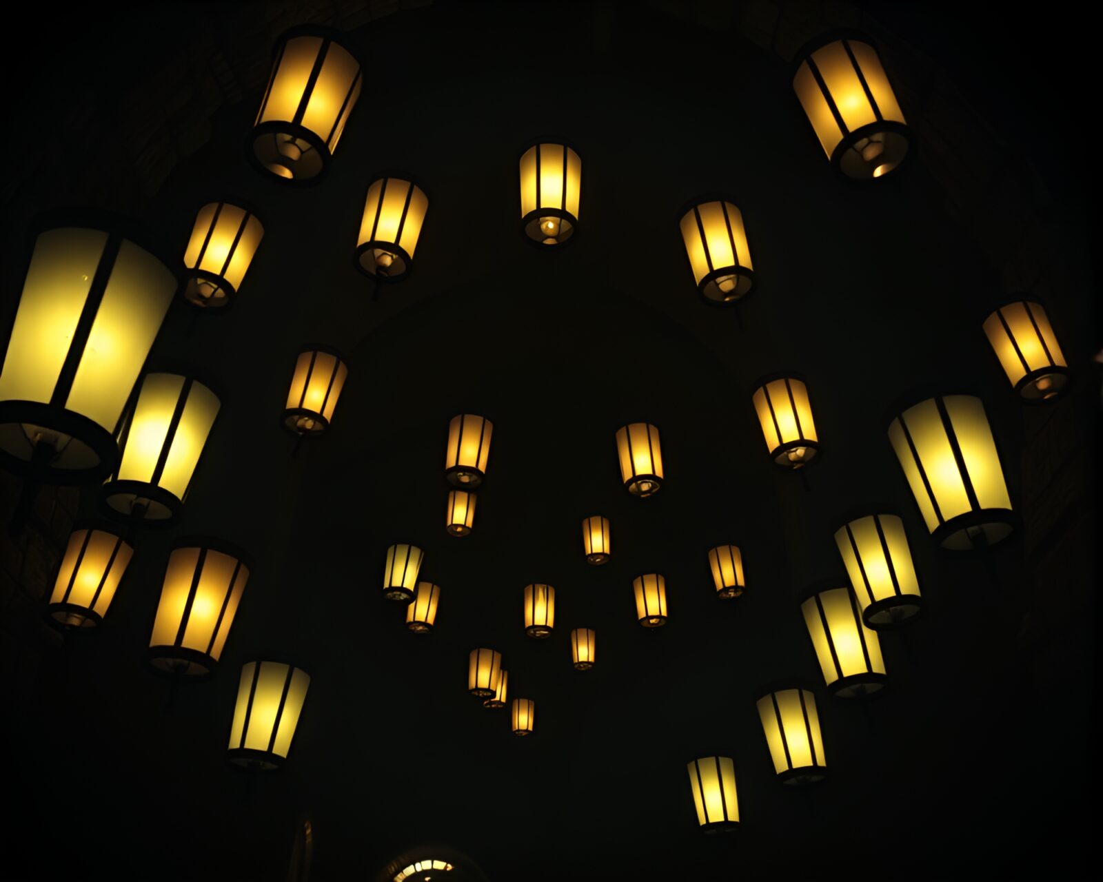 Circular frame with lanterns casting shadows in torchlit dungeon