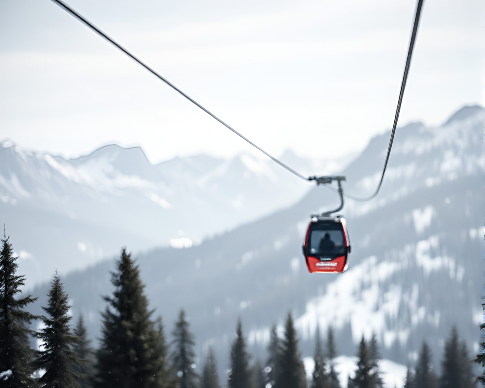 Selective focus on wooden gondola lift amidst snowy peaks