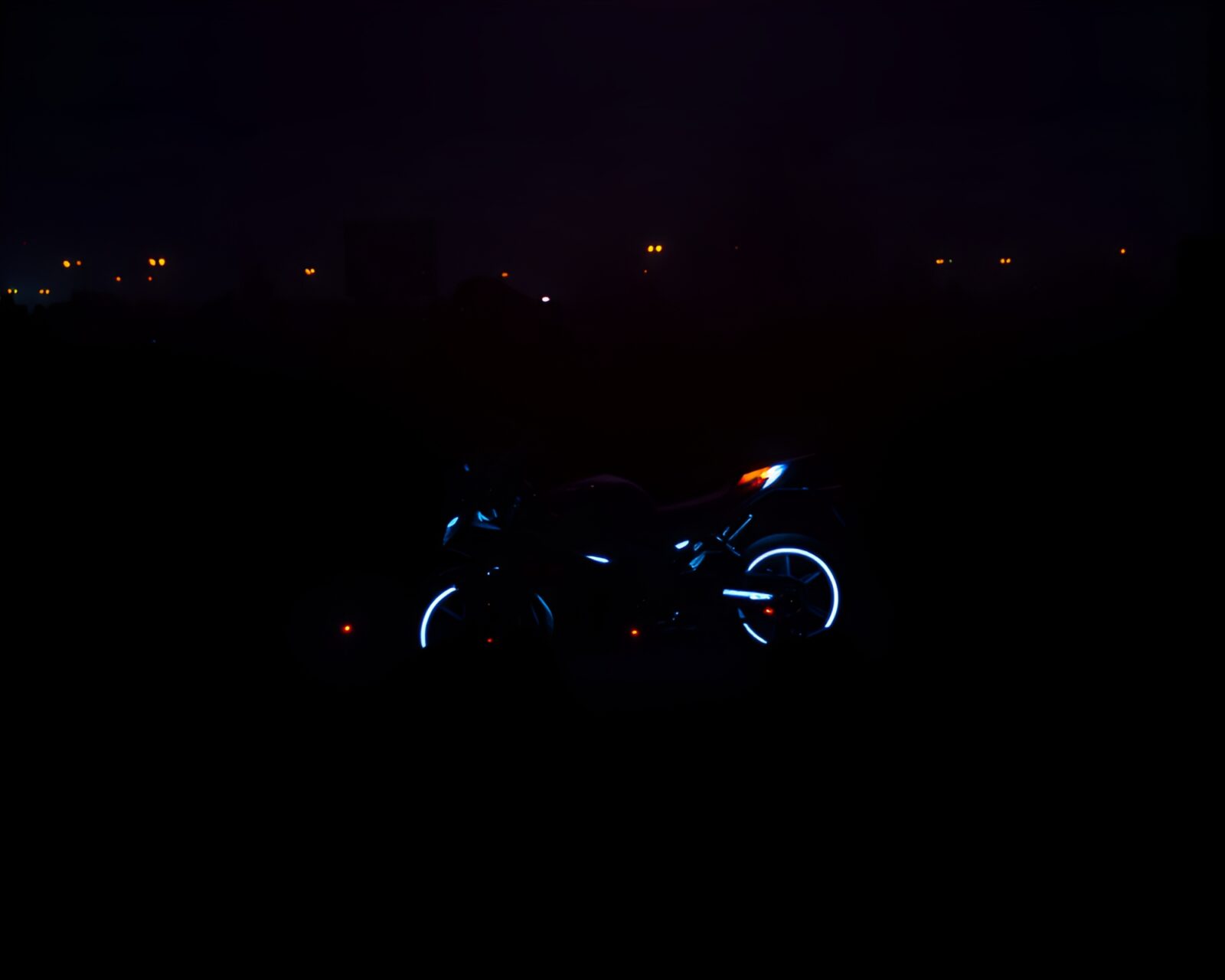 Silhouettes of crowd on glowing hoverbikes at night