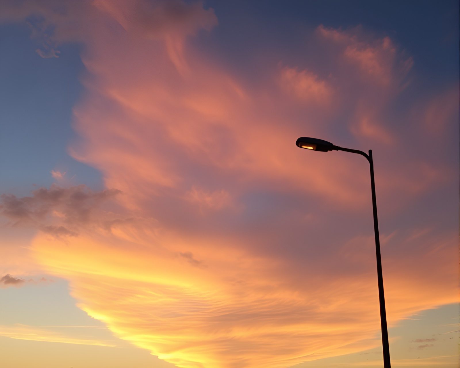 Pastel sky with surreal clouds and neon streetlamp