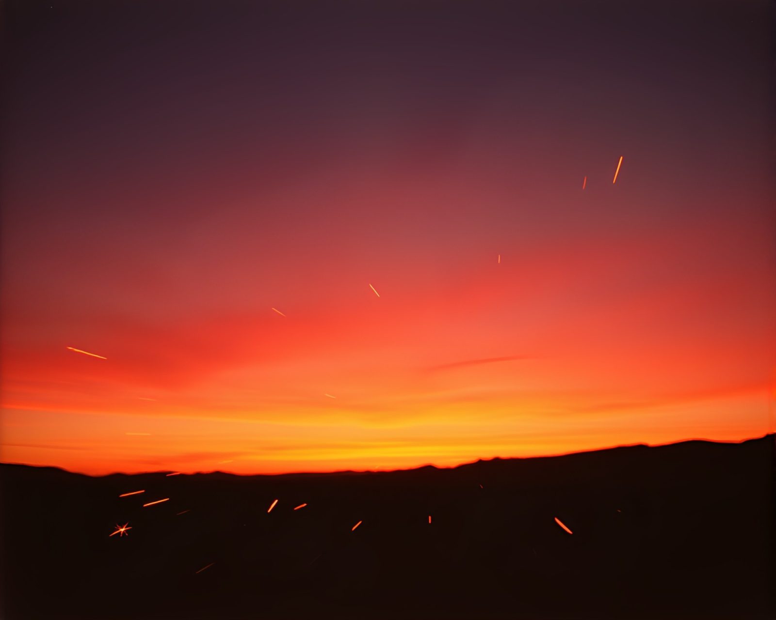 An ethereal scene of sparkling trails under a desert sunset