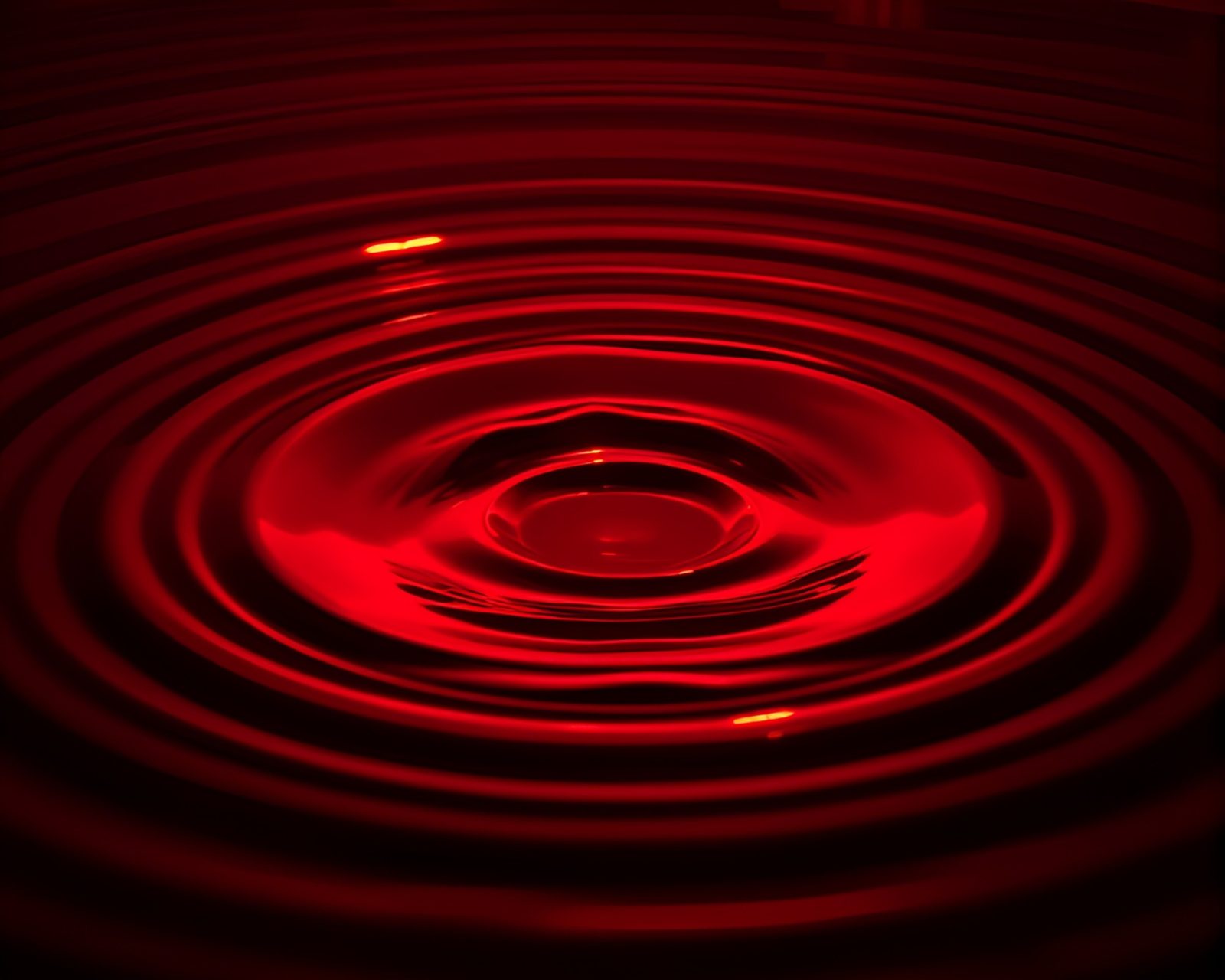 Vibrant ruby red rings reflecting on rippling water surface